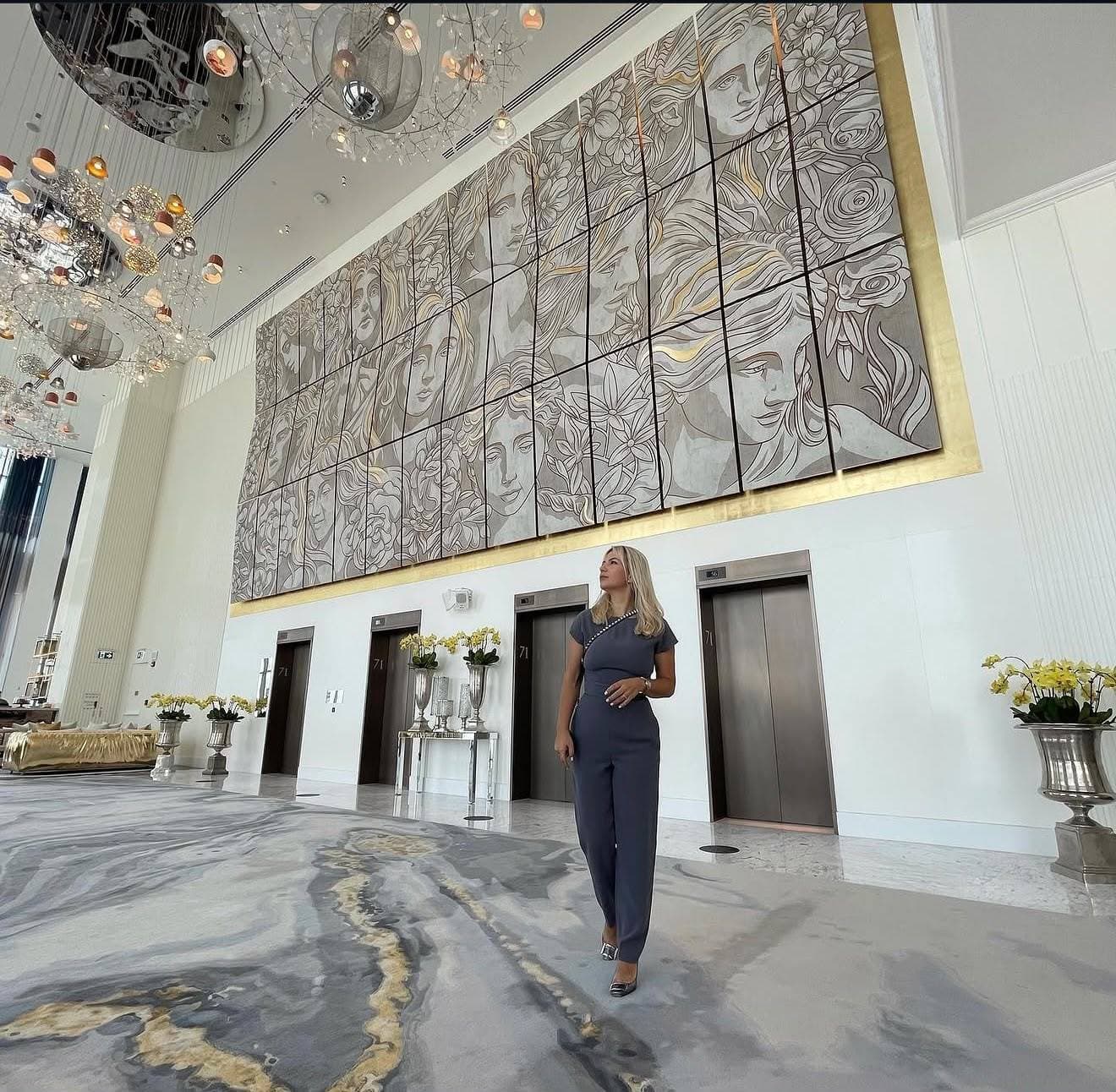 Jasmina Vujisic in the lobby of the SLS Hotel, Dubai, beneath the wood and metal installation she created for it